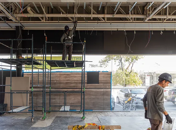 Instalação elétrica em andamento Trabalhadores realizando instalação elétrica no teto durante obra