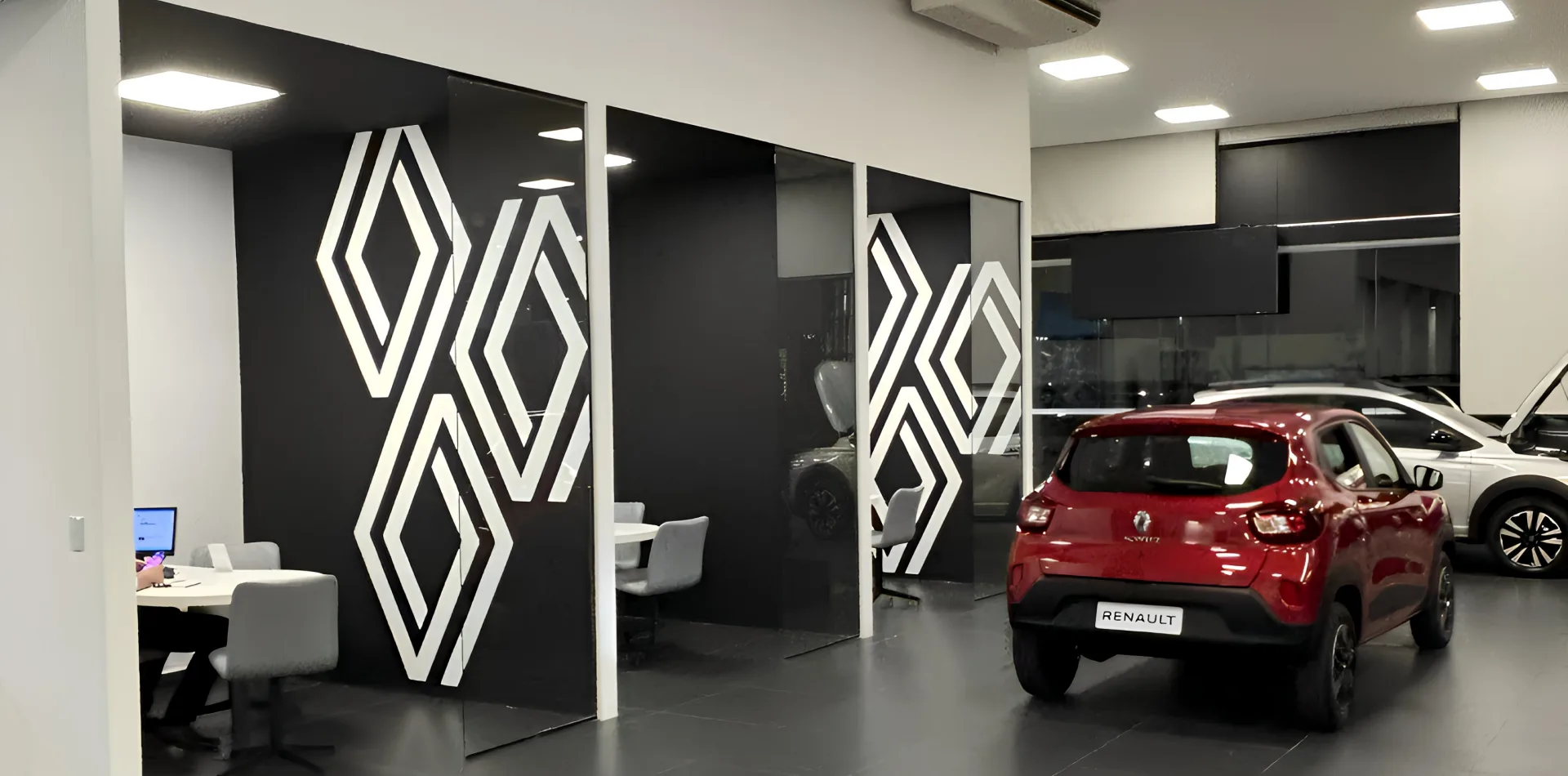 Showroom automotivo com divisórias pretas e grafismos brancos geométricos